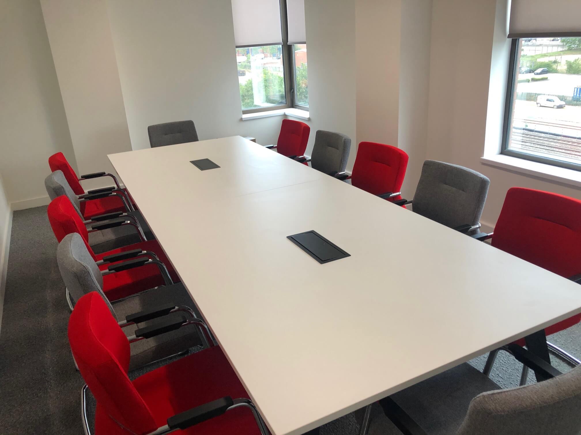 office meeting desk with red and grey chairs